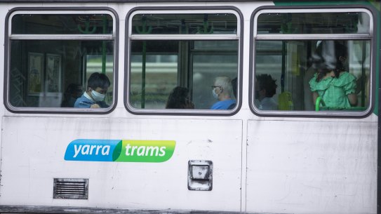 Commuters don their masks on a Melbourne tram. 