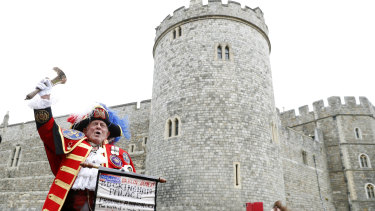 An unofficial Town Crier announces the birth of Baby Sussex outside Windsor Castle.