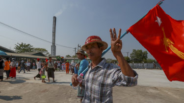 A man carrying a flag of the National League for Democracy party flashes the three-fingered salute during the funeral of Tin Htut Hein in Yangon, Myanmar on Wednesday.