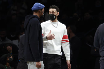 Ben Simmons speaks with new teammate Kevin Durant on the sidelines of a Brooklyn Nets home game this week.
