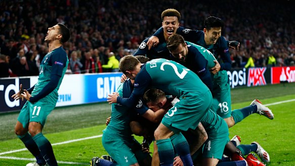 Triumphant: Tottenham players following Moura's third and decisive strike.
