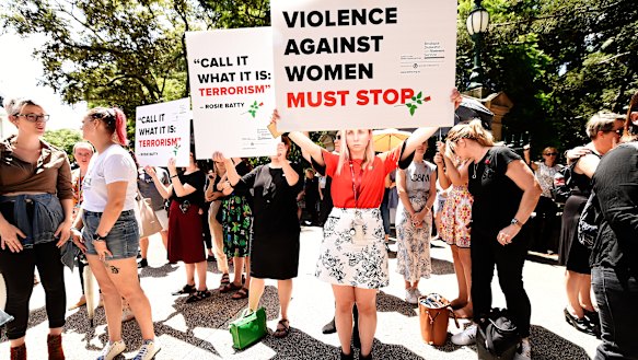 Protesters hold placards during a domestic violence protest organised by The Red Rose Foundation in Brisbane, Friday, February 21, 2020. 