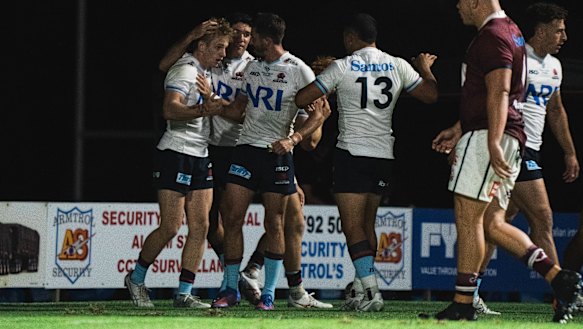 The Waratahs celebrate with teen rookie Max Jorgensen, who scored against the Reds in Narrabri.