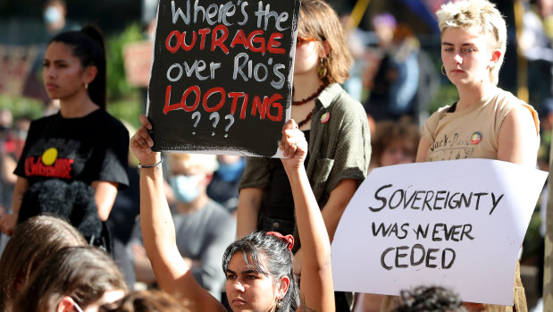 Protesters are seen during a rally outside the Rio Tinto office in Perth.