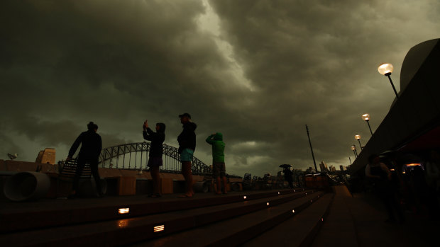 Pedestrians watch a storm cell above Circular Quay on Saturday.