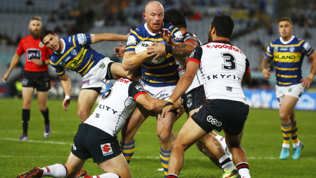 Beau Scott of the Eels is tackled by the Warriors defence.