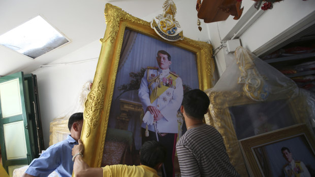 Thai workers prepare to transport a giant portrait of Thailand's King Maha Vajiralongkorn in the lead up to his coronation.