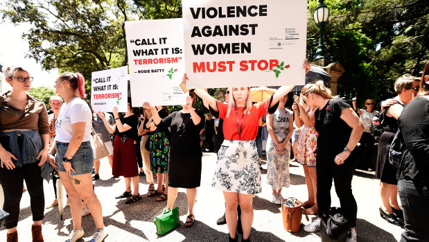 Protesters hold placards during a domestic violence protest organised by The Red Rose Foundation in Brisbane, Friday, February 21, 2020. 