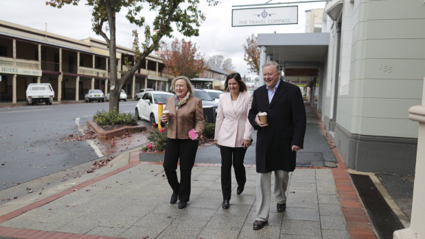 Kristy McBain and Anthony Albanese walk a cold, empty street in Yass with Yass Valley mayor Rowena Abbey (left).