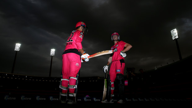 Josh Philippe and Daniel Hughes prepare to bat for the Sixers as storm clouds gather overhead.