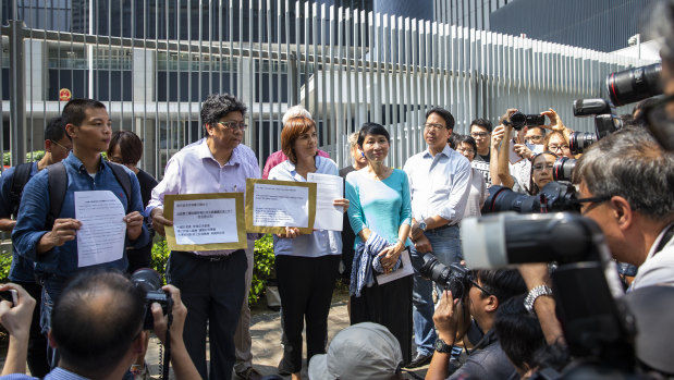Members of the Alliance of Hong Kong Media with statements and a petition during a rally outside the Central Government Offices in Hong Kong.
