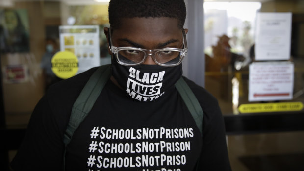 A demonstrator stands outside the school board headquarters during a protest Monday in Los Angeles. 