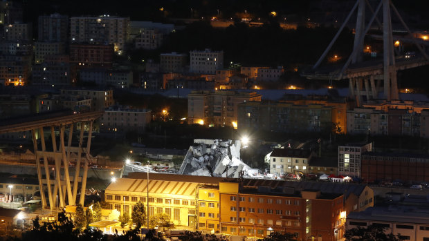 Lamps illuminate the area where rescue teams search for survivors in the rubble of the collapsed Morando highway bridge in Genoa.