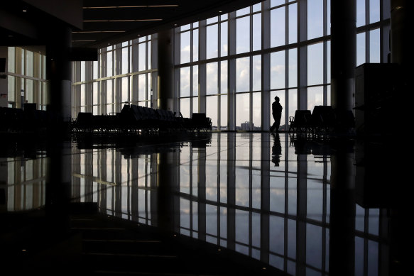 Pandemiden bu yana endişe duyguları arttı: Bir kadın, Atlanta'daki bir havaalanında neredeyse boş bir terminale pencereden bakıyor. 