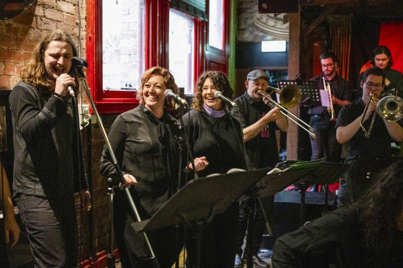 James Coomans singing karaoke supported by Belinda Parsons (2nd from left).