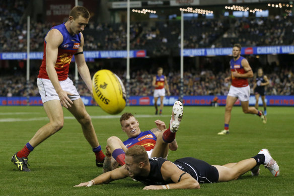 Harry McKay of the Blues and Brisbane’s Mitch Robinson collide.