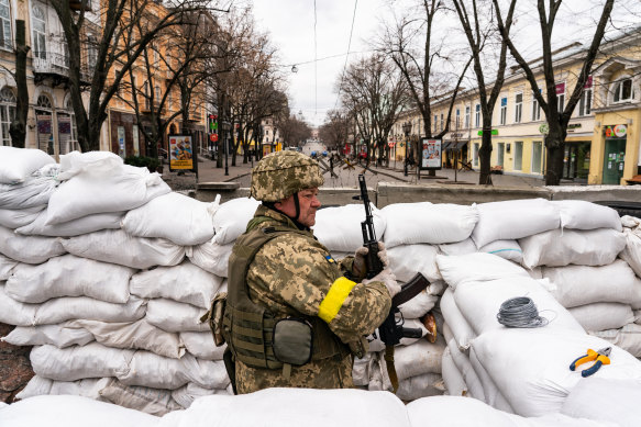 A Ukrainian soldier stands guard among the sandbags in downtown Odesa on Saturday. 