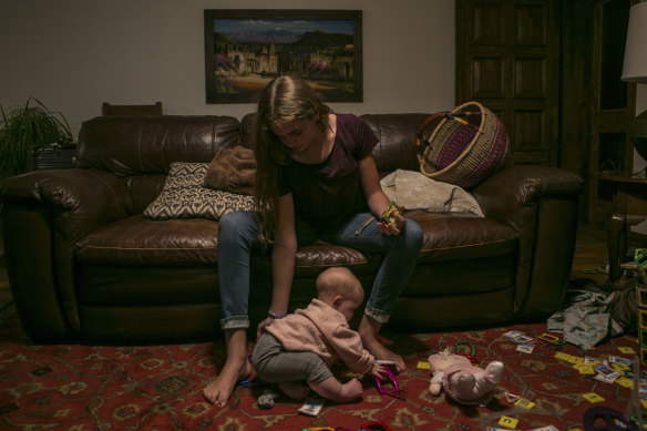 Evelyn Langford, 13, Christina's youngest sister, plays with Faith, Christina's daughter who survived the ambush.