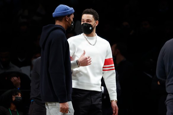 Ben Simmons speaks with new teammate Kevin Durant on the sidelines of a Brooklyn Nets home game this week.