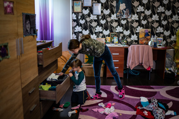 Anya, 16, helps her foster sister Alina, 6, fold clothes on February 21 after packing their belongings in case they need to evacuate from their home in Zolote, in Ukraine’s east.