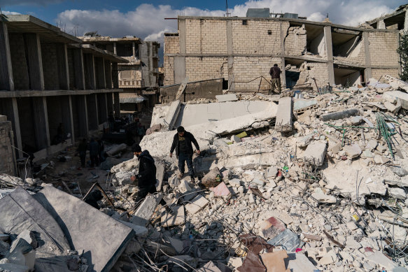 Locals look through the rubble of a building that was destroyed in Jinderis, Syria.
