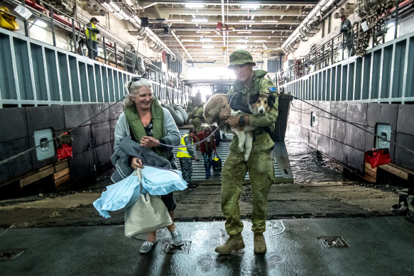 Evacuees board HMAS Choules for the trip back to Melbourne.