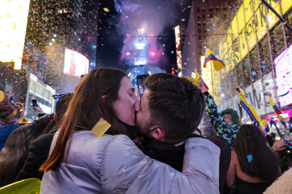 İspanya'dan gelen ziyaretçiler, 1 Ocak 2022 gece yarısından kısa bir süre sonra New York'taki Times Meydanı'nda kutlama yaparken öpüşürler.