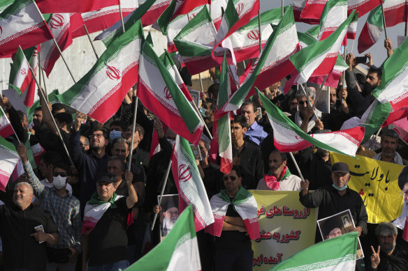 Pro-government demonstrators wave Iranian flags during their rally condemning recent anti-government protests over the death of Mahsa Amini.