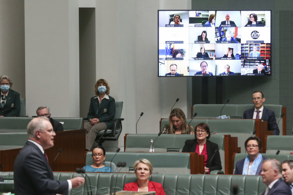 Prime Minister Scott Morrison responds to a question as "remote" MPs hover over the chamber. 