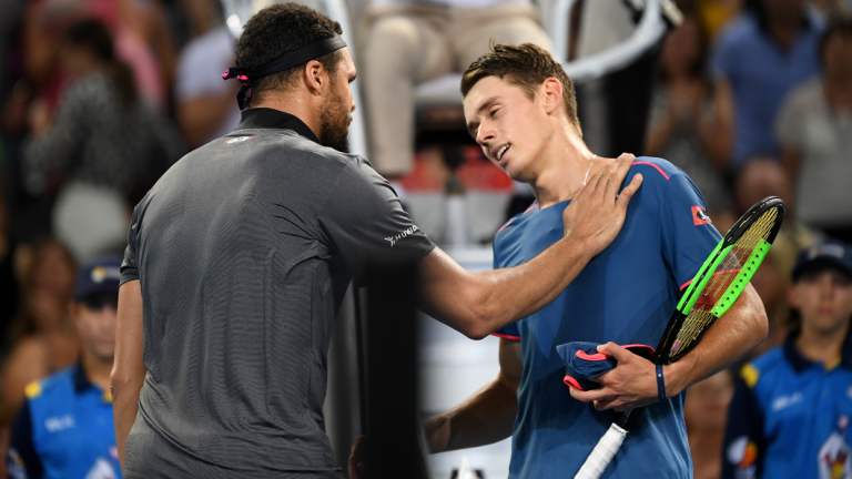 Jo-Wilfried Tsonga of France (left) and Alex De Minaur of Australia exchange words after Tsonga won their quarter final match at the Brisbane International tennis tournament.