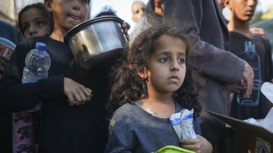 A Palestinian girl queues for food in Deir al-Balah, Gaza Strip, on Monday.