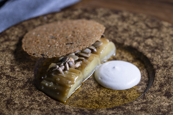 Wood-charred leek with cashew cream, brown butter and a crisp disc of chicken skin.