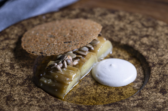 Wood-charred leek with cashew cream, brown butter and a crisp disc of chicken skin.