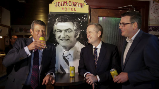 Former premier Steve Bracks, then-opposition leader Bill Shorten and Premier Daniel Andrews share a beer in memory of former prime minister Bob Hawke at The Curtin in 2019, after the death of Mr Hawke.