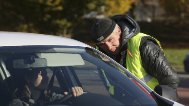 A protester talks to a driver as French drivers block a traffic circle near an oil depot in Vern-sur-Seiche, western France.