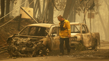 A Sonoma Valley firefighter inspects burned out cars to check for human remains.