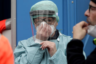 Medical staff wearing protective masks work at one of the emergency structures that were set up to ease procedures at the Brescia hospital, northern Italy.