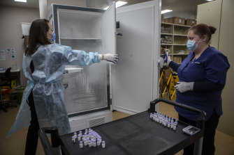 Monash Medical Centre pharmacists Nicole Dirnbauer (left) and Sigourney Szelag take Pfizer vials from an ultra-cold freezer.