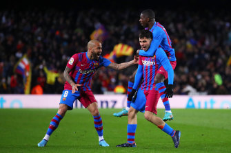 Pedri celebrates a goal for FC Barcelona with teammates Dani Alves (left) and Ousmane Dembele.