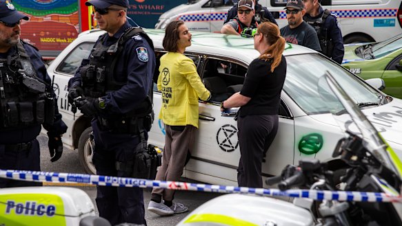 Extinction Rebellion activist Eric Herbert (centre) is seen participating in a protest outside 1 Williams Street.