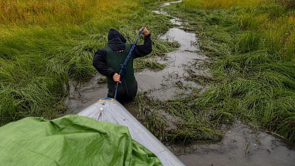 Philip Hanke pulls the boat carrying scientific supplies through a narrow passage. 