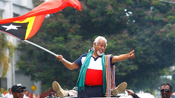 East Timorese independence hero Xanana Gusmao waves a national flag at a pre-election rally.