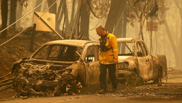 A Sonoma Valley firefighter inspects burned out cars to check for human remains.