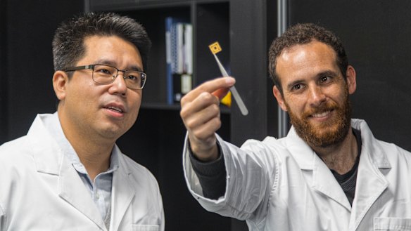 Dongchen Qi (left) with QUT student David Sommers and one of the team's diamond circuits.