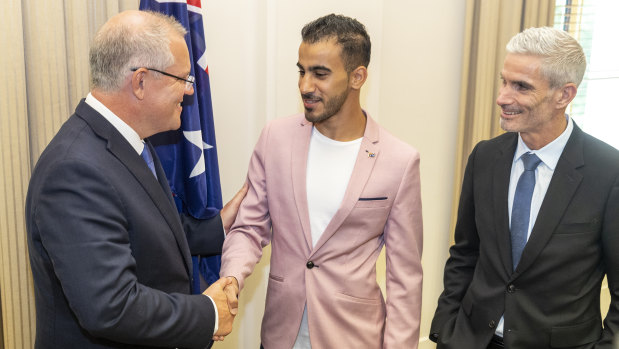 Welcome aboard: Craig Foster looks on as Prime Minister Scott Morrison congratulates Hakeem al-Araibi on his Australian citizenship.