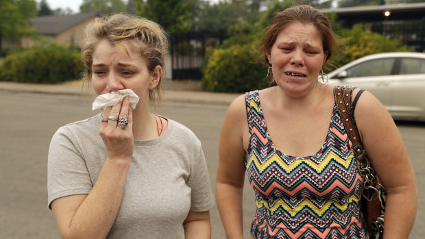 Sherry Bledsoe, left, cries next to her sister, Carla, outside the sheriff's office after hearing news that Sherry's children, James and Emily, and grandmother, Melody Bledsoe, were killed in the fire on Saturday.