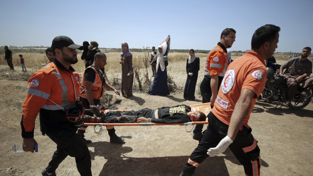 Palestinian medics evacuate a wounded man during a protest by the Israeli border with Gaza Strip on Wednesday.