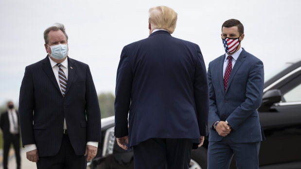 US President Donald Trump is greeted by Kurt Heise, left, Supervisor of Plymouth Township, Michigan, and Michigan House Speaker Lee Chatfield, right, in May during a campaign visit. 