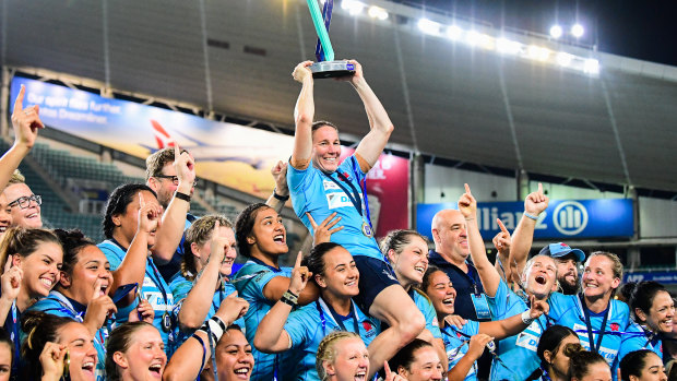 History: Ash Hewson holds the trophy aloft as NSW players celebrate their Super W title.