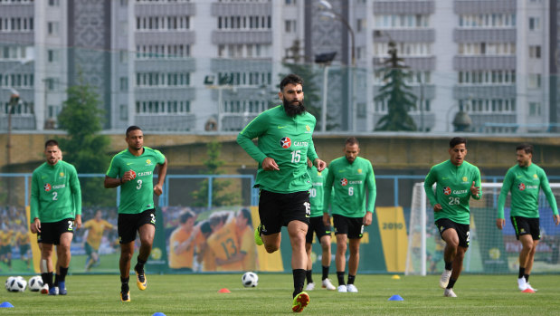 Leading the way: Mile Jedinak strides out with the Socceroos squad at their base in Kazan.